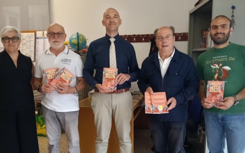 Santa in Giallo distribuisce libri agli studenti della scuola media Vittorio G. Rossi